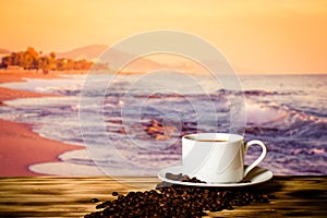 Coffee beans and coffee in cup on wooden table opposite a blurred background photo