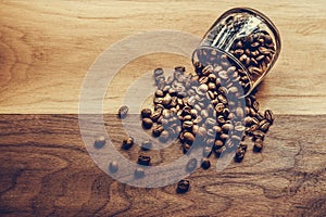 Coffee beans in a coffee cup on a wooden table. top view of medium roasted coffee beans for coffee drip on wooden table background