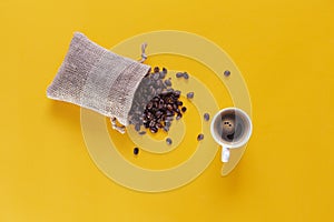 Coffee beans coming out of a sack and a cup