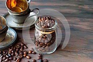 Coffee beans in a cristal jar on a brown wooden background