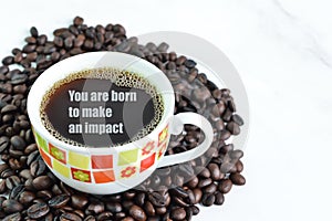 Coffee beans and a cup of coffee with text YOU ARE BORN TO MAKE AN IMPACT