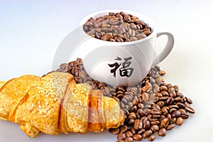 Coffee beans with cup and croissant