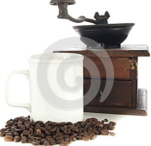 Coffee beans, cup and grinder on white