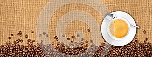 Coffee beans and cup on natural burlap texture