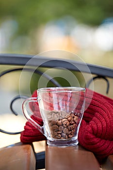 Coffee beans in a cup with red scarf on the table .
