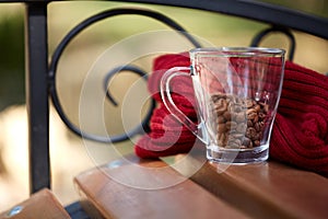 Coffee beans in a cup with red scarf on the table .