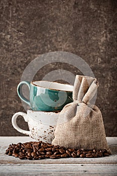 Coffee beans and cups on wooden table