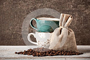 Coffee beans and cups on wooden table