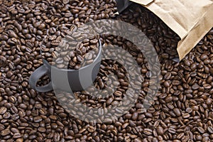 Coffee beans in dark cup on mixed coffee beans background