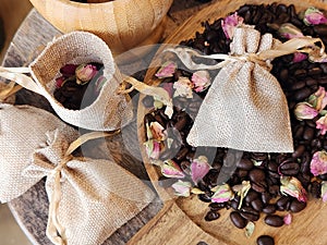 Coffee beans and dried rose buds aromatherapy sachets and mortar.