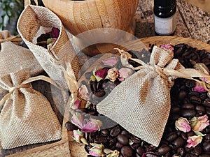 Coffee beans and dried rose buds aromatherapy sachets and mortar.