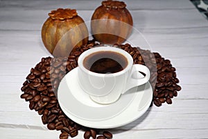Coffee beans and espressocup on a wooden board