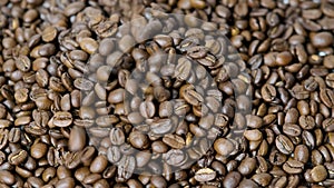 Coffee beans are falling. Brown roasted coffee beans falling on pile. Represent breakfast, energy, freshness or great