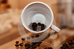 coffee beans falling from an inverted white cup