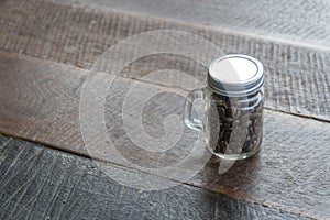 Coffee beans in glass bottles with old wood floor