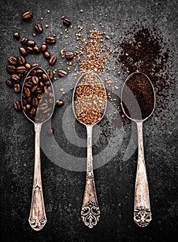 Coffee beans, ground coffee and instant coffee on spoons