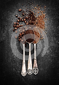 Coffee beans, ground coffee and instant coffee on spoons