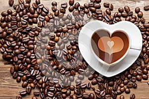 Coffee beans and ground coffee with small cup on wooden background