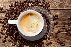 Coffee beans and ground coffee with small cup on wooden background