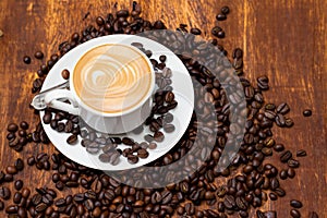 Coffee beans and ground coffee with small cup on wooden background