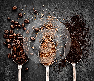 Coffee beans, ground coffee and instant coffee on spoons