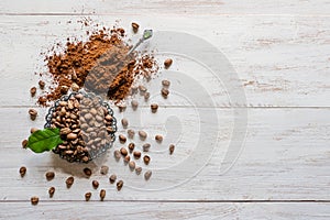 Coffee beans and ground powder on white wooden background. Top view with copy space