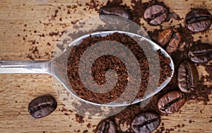 Coffee beans and ground seeds on a spoon.