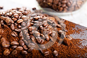 Coffee Beans and Grounds Close up. Background. Coffee beans in a glass jar in the background