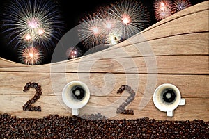 Coffee beans and hot fresh coffee in a white cup with foam and text number design 2024 for Happy New Year Concept. with fireworks