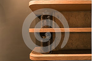 Coffee beans in jar standing on wooden shelf on wall.