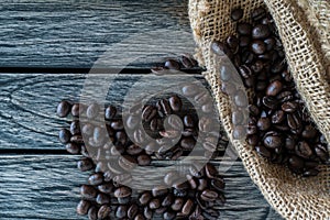 Coffee beans in jute sack on wooden background