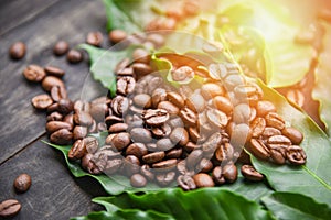 Coffee beans on leaf / Roasted coffee on dark wooden table background in the morning