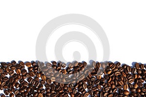 Coffee beans lie scattered on a white isolated background.