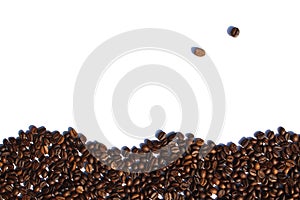 Coffee beans lie scattered on a white isolated background.