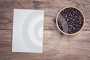 Coffee beans and and lined paper on wooden table top view