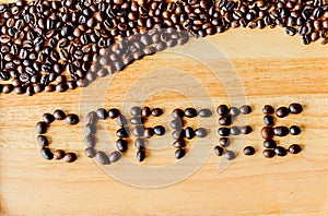 Coffee beans are literally `coffee` on a wooden floor.
