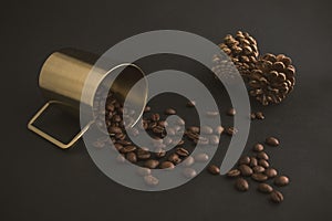 Coffee beans, metal cup, and background with pine cone