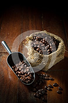 Coffee beans in metal scoop and gunny sack.