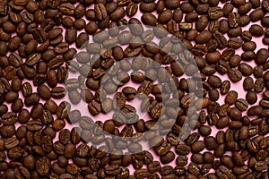 Coffee beans on a pink background from above,Coffee espresso.Coffee grains.Coffee black