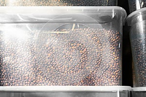 coffee beans in plastic containers. a lot of roasted