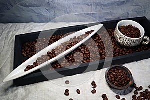 Coffee Beans in a porcelain boat and a coffee cup