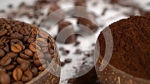 Coffee beans and powder inside coconut bowls with coffee pods in the background. Close up view. Organic food