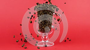 Coffee beans quickly pour, latte glass cup, red background. Refreshing concept