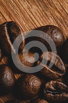 Coffee beans roasted on wooden background Close up macro copy space