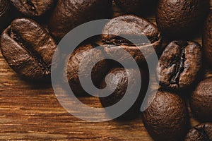Coffee beans roasted on wooden background Close up macro copy space