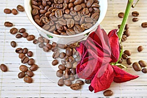 Coffee beans are scattered on the table. Dried rose on the table.