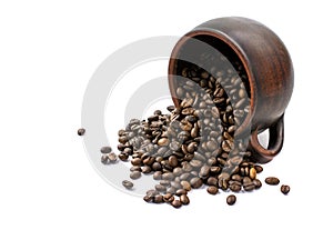 Coffee beans are scattered from an upturned earthenware mug on a white isolated background