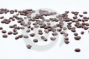 Coffee beans scattered on white background