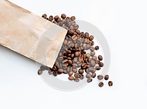 Coffee beans are scattered on a white background. coffee with a paper bag. coffee and the environment.