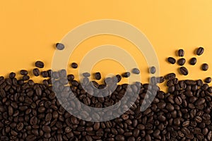 Coffee beans are scattered on a yellow paper background close-up, concept, commercial copy space
